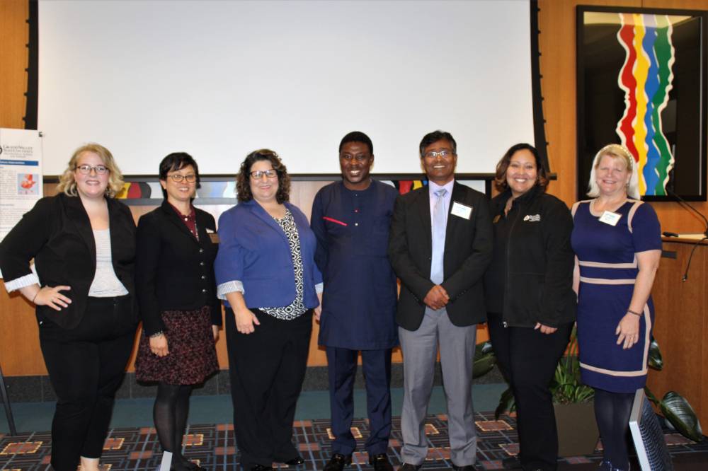 Image 1 of 15 The Global Health Task Force committee standing together with the keynote speaker, smiling
